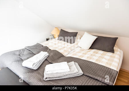 Neue, saubere europäische Zweibettzimmer Doppelzimmer Queen-Size-Bett mit Daunendecke schräge Decke, Tisch, Lampe, dekorative neutral kissen im Schlafzimmer staging Modell Heim, Haus Stockfoto