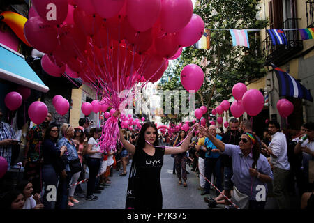 Eine der Frauen, die als freiwillige Arbeit vertreibt rosa Luftballons. Die High Heels Rennen ist eine der Aktivitäten, die während der Lgbt Gay Pride Festivals im Chueca Nachbarschaft, Madrid toke. Stockfoto