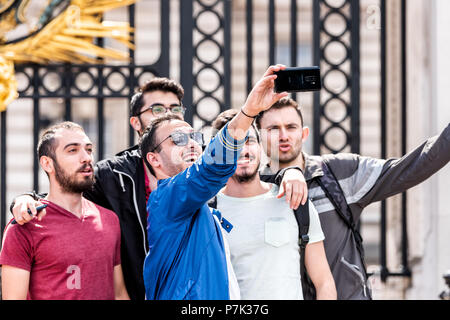 London, UK, 21. Juni 2018: Die Gruppe der jungen Männer männliche Gesichter Freunde stehen dabei glücklich selfie Lächeln und Lachen vor dem Buckingham Palace Clos Stockfoto