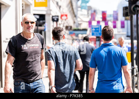 London, Großbritannien, 22. Juni 2018: die Masse von viele Leute Mann Fußgänger gehen auf Piccadilly Bürgersteig Straße Straße in der Mitte von Downtown City, England flag o Stockfoto