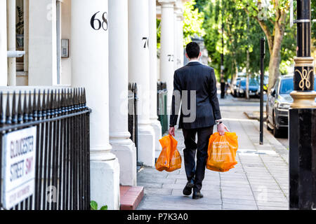London, Großbritannien, 22. Juni 2018: Nachbarschaft Stadtteil Pimlico, Gloucester Street, Geschäftsmann Mann einkaufen Taschen nach der Arbeit am Abend Stockfoto
