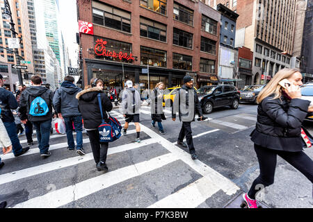 New York City, USA, 6. April 2018: Manhattan NYC Gebäude von Midtown Herald Square, 6 Avenue Road, Zeichen Masse von Menschen zu Fuß überqueren auf Stree Stockfoto