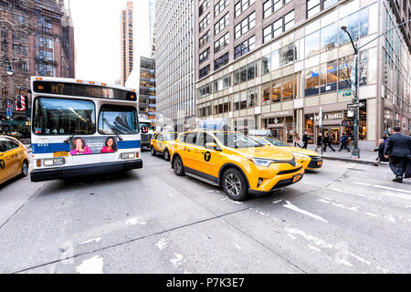 New York City, USA, 6. April 2018: Manhattan NYC Gebäude von Midtown Herald Square, Straße, Zeichen, Autos, Bus warten auf 6. Avenue, gelben Taxis Stockfoto