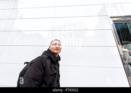 New York City Manhattan Midtown New York Herald Square, 6. Avenue Road, glückliche Person Mann Person wandern, schauen, Reflexion über Fliesen- wand Stockfoto