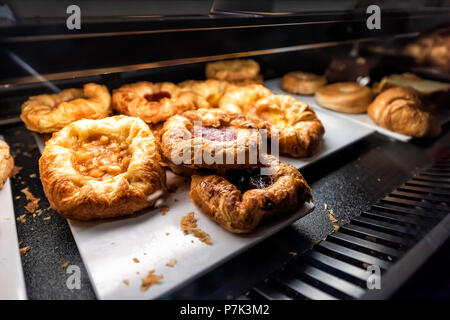 Nahaufnahme von vielen gelben Dessert Beerenfrucht apple gebackenes Gebäck auf dem Regal Fach an Desserts in Bäckerei cafe Store dunklen Zähler Stockfoto
