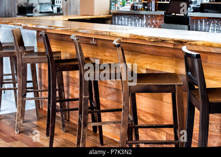 Reihe von leeren Holz- vintage Barhocker durch Gegendruck im Getränk Gründung Pub tagsüber Muster Nahaufnahme, retro Holz und niemand Stockfoto