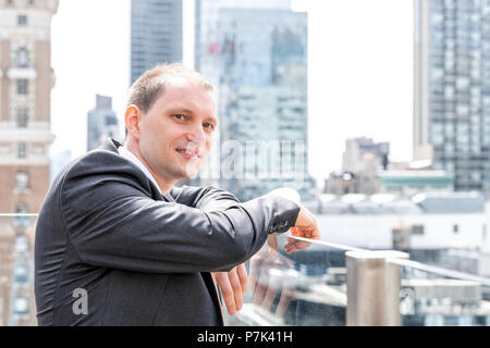 Stattlich, attraktive junge Seite Profil Geschäftsmann Nahaufnahme Gesicht Porträt in Anzug, Krawatte, an der New York City Skyline Skyline in Manhatt Stockfoto