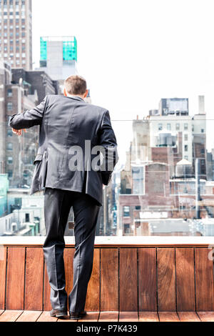 Der junge Unternehmer stehen in zerknitterten Anzug auf der Suche nach unten an der New York City Skyline Skyline in Midtown Manhattan nach Interview Brea Stockfoto