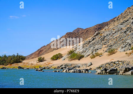 Stony felsigen Hang mit Sand drift auf dem Südafrikanischen steilen Ufer des Orange River/Oranjerivier (Grenzfluss) zwischen Namibia und Südafrika, Namibia, Südafrika, Aussenkehr Nature Reserve Stockfoto