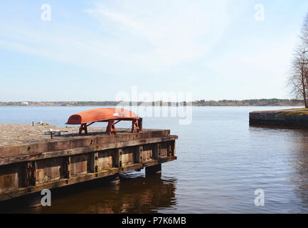 Umgedrehten roten Boot auf einem Pier oben noch Wasser am Ufer des Seefestung Suomenlinna in Finnland Stockfoto