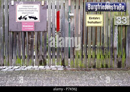 Viele verschiedene Verkehrszeichen auf der hölzernen Zaun einer Auffahrt, Stockfoto