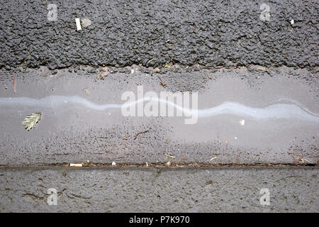 Öl Film/Öl auf dem nassen Asphalt der Straße trace Stockfoto