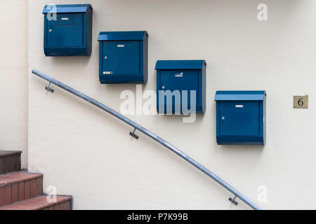 Blaue Briefkästen entlang eine absteigende Treppe Geländer. Stockfoto