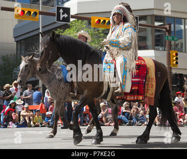 Der Mann in traditioneller einheimischer Kleidung reitet auf dem Pferderücken in der Calgary Stampede Parade. Die Parade durch die Innenstadt beginnt jedes Jahr mit der Calgary Stampede. Alberta, Kanada. Rosanne Tackaberry/Alamy Live News Stockfoto