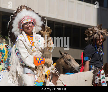 Der Mann in der traditionellen Stoney Nakoda-Kleidung fährt bei der Calgary Stampede Parade. Die Parade durch die Innenstadt beginnt jedes Jahr mit der Stampede. Alberta, Kanada. Stockfoto
