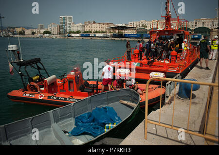 Malaga, Spanien. 7. Juli 2018. Ein beiboot der Migranten ist neben einem Rettungsboot nach der Ankunft der 24 Migranten an den Hafen von Malaga. Mitglieder der Spanischen Sicherheit auf See gerettet 24 Migranten an Bord ein Beiboot in der Nähe der Küste von Malaga und brachte am Hafen von Malaga, wo sie durch das Spanische Rote Kreuz unterstützt wurden. Credit: SOPA Images Limited/Alamy leben Nachrichten Stockfoto