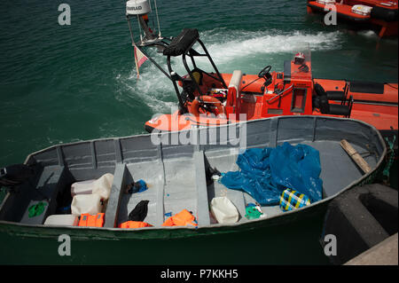 Malaga, Spanien. 7. Juli 2018. Ein beiboot der Migranten ist neben einem Rettungsboot nach der Ankunft der 24 Migranten an den Hafen von Malaga. Mitglieder der Spanischen Sicherheit auf See gerettet 24 Migranten an Bord ein Beiboot in der Nähe der Küste von Malaga und brachte am Hafen von Malaga, wo sie durch das Spanische Rote Kreuz unterstützt wurden. Credit: SOPA Images Limited/Alamy leben Nachrichten Stockfoto