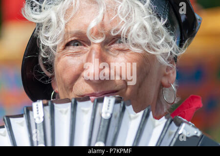 Paisley, Schottland, Großbritannien. 7. Juli 2018. Eine weibliche Musiker spielen auf der Ziehharmonika während der Feier der Sma" Tag in der Parade durch die Straßen von Paisley Reisen von Brodie Park an Abbey schließen. Sma' Tag hat seinen Namen von einem berühmten Sieg zwischen den Schal Weber und der Kork (die mittlere Mann) im 19. Jahrhundert. Die sma' ist ein feiner Schussfaden, in Paisley Schals gewebt durch die Weber, für die Sie nicht bezahlt wurden. Im Jahre 1856 wurde eine Vereinbarung erreichte schließlich für die sma' zu zahlen. Credit: Skully/Alamy leben Nachrichten Stockfoto