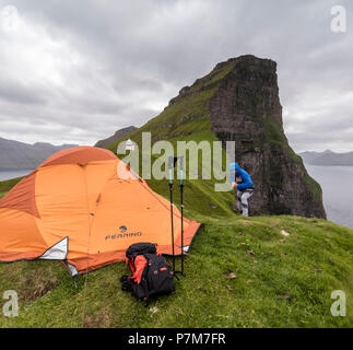 Wanderer und Zelt auf Felsen um kallur Leuchtturm, Kalsoy Island, Färöer, Dänemark Stockfoto