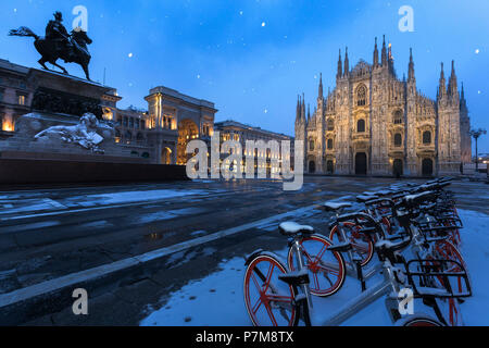 Fahrräder in PIazza Duomo bei Schneefall bei Dämmerung, Mailand, Lombardei geparkt, Norditalien, Italien, Stockfoto