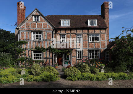 Drei reizende Geschichte 17 Country House in England mit Ziegel gebaut Infill auf einem Holzrahmen, die Bauhölzer ausgesetzt, großen Schornsteine, & Wisteria Stockfoto