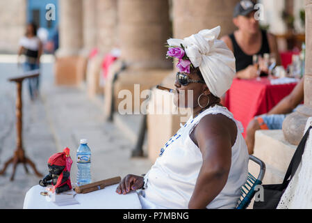 Theresa die Wahrsagerin eine kubanische Zigarre rauchen und genießen das schöne Wetter auf der Plaza de la Catedral, Havanna, Kuba. Stockfoto