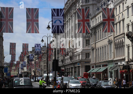 Blick auf den Strand in London, UK Richtung Trafalgar Square, viele Fahnen auf Kabel über die Straße hoch über Fußgänger und Verkehr aufgehängt. Stockfoto