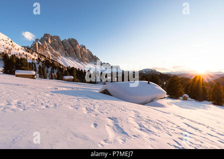 Einen schönen Sonnenuntergang auf der Geisler im Villnössertal mit einer Gruppe von Hütten im Vordergrund, Provinz Bozen, Südtirol, Trentino Alto Adige, Italien, Stockfoto