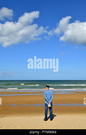 Frankreich, Calvados, Cote de Nacre, Strand von Vierville-sur-Mer, Omaha Beach, Amerikanischer Veteran sammeln einige Sand am Strand Stockfoto