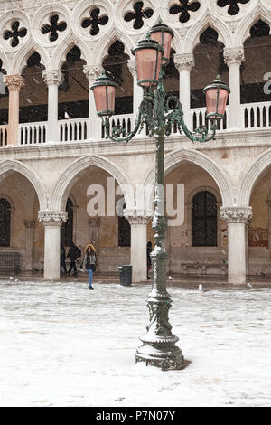 Ein Tourist in St. Markusplatz, Dogenpalast, während eines Schneefalls, Venedig, Venetien, Italien Stockfoto