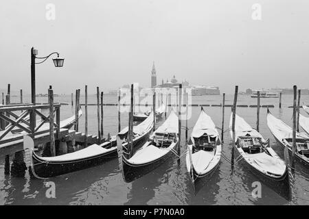 Einige der traditionellen venezianischen Gondeln vertäut an der Riva degli Schiavoni während einem Schneefall, Venedig, Venetien, Italien Stockfoto