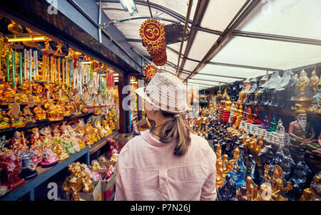 Touristische Frau in Hut und rosa Hemd am Markt mit Souvenirs in Bangkok, Thailand Stockfoto