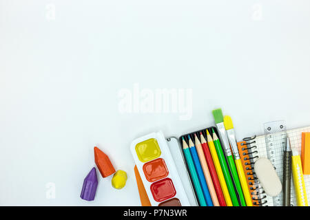 Schule stationäre und Tools für Kinder. notebook, Farbe, Bleistifte auf weißem Schreibtisch Oberfläche, flache Ansicht Stockfoto