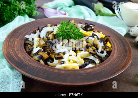 Pikanter Salat von gebratenen Auberginen, gekochtes Ei, marinierten Zwiebeln in eine Schüssel geben. Stockfoto