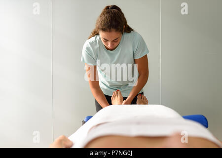 Medizinische Massage am Fuß in der Physiotherapie. Weiblichen Physiotherapeuten ihre Patienten untersuchen. Stockfoto