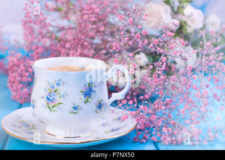 Morgen duftenden Kaffee in einem vintage Schale, rosa Blüten und blauem Hintergrund. Platz kopieren Stockfoto