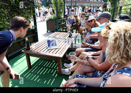 Tennisturniers beobachten das Endspiel der englischen Fußball-Weltmeisterschaft im Viertelfinale gegen Schweden auf einem Tablet am sechsten Tag der Wimbledon-Meisterschaft im All England Lawn Tennis and Croquet Club, Wimbledon. Stockfoto