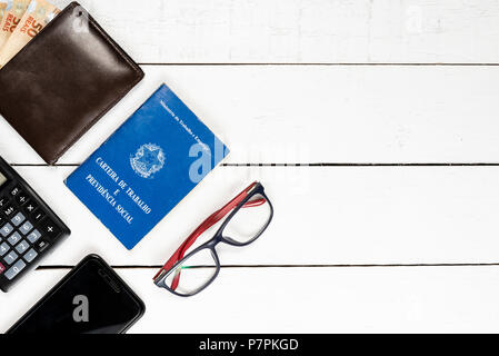Arbeitserlaubnis, Portemonnaie, Brasilianische Geld, caclulator, Gläser, cellphone, weißer Hintergrund, Platz für Text, Pinus Hintergrund, Objekte auf der linken, oberen vi. Stockfoto