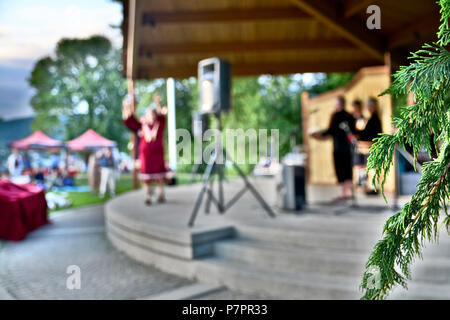 Aboriginal Carver, James Harry und Unterstützer stellt seinen neuen Totem, das Publikum zu begeistern. Aus der Sicht der Bühne bei PCT, Port Moody, BC Kanada Schuß Stockfoto