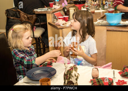 Zwei hübsche, junge Mädchen, im Alter zwischen 5 und 8, am Tisch sitzen, tosting einander. Cranbrook, BC, Kanada. Model Released nach rechts - #113, #104, Stockfoto