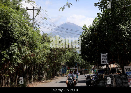 Amed, Indonesien - 3. Juli 2018: Der Vulkan Mount Agung erhebt sich über einem Dorf in Ost Bali, Indonesien Stockfoto