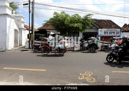 Jogjakarta, Indonesien - 22. Juni 2018: eine Rikscha Fahrer Zyklen seine Karre entlang einer Straße in das Sultan's Palace Complex in Jogjakarta Stockfoto