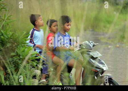 Drei Jungen reiten Motorräder in Bandung, Indonesien. Stockfoto