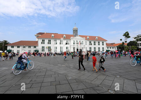 Jakarta, Indonesien - 20. Juni 2018: Einheimische, die zu Fuß und mit dem Fahrrad durch Fatahillah Square in der Alten Stadt Jakarta (Batavia) während ein nationaler Feiertag Stockfoto