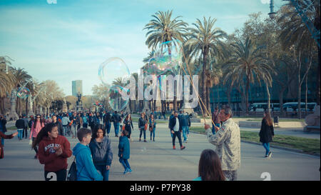 BARCELONA, SPANIEN - 27. März 2017: Fußgänger-Allee in Ciutadella Park durch eine Straße Mann, unterhält Kinder die immensen/giant Soap bu Animierte Stockfoto