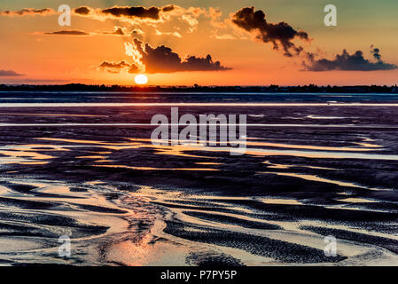 Orange sunrise Licht an der Mündung der Somme River. Der Himmel ist in den Pfützen der Ebbe wider Stockfoto