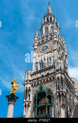 Die Mariensäule, die Uhr schlägt und der Turm des Neuen Rathauses in München, Deutschland Stockfoto