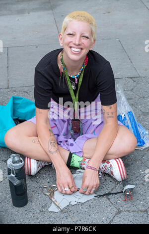 Stellen Portrait von eine hübsche junge Dame mit kurzen blonden Haaren und mehrere kleine Tattoos. Im Union Square Park in New York City. Stockfoto