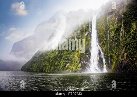 Wasser aus Niederschlag ergiesst sich Berghänge. Milford Sound im Fjordland, Südinsel, Neuseeland. Stockfoto