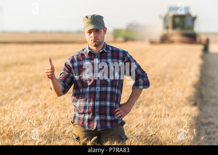 Junge Landwirt in Weizen Feld während der Ernte im Sommer Stockfoto